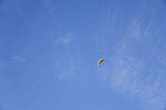 Paragliding on a sunny day with cirrus clouds, enjoying freedom and adventure in ronda, malaga,