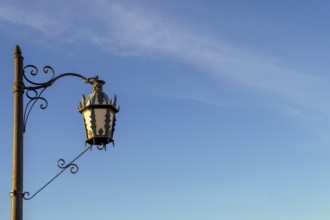 Ornate street lamp with wrought iron detail stands against a clear blue sky in ronda, malaga, spain