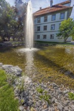 Small pond with water fountain in the castle park in Kisslegg, Allgäu, Baden-Württemberg, Germany