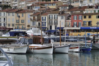 Cassis, the port, Boats docked in a harbor with colorful buildings lining the waterfront on an