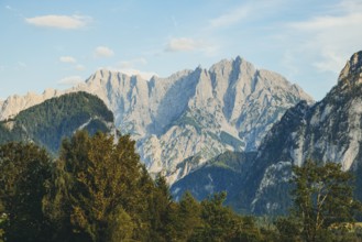 Imposing mountain peaks, Hochtor and Großer Ödstein, rise above wooded hills, Weng im Gesäuse,