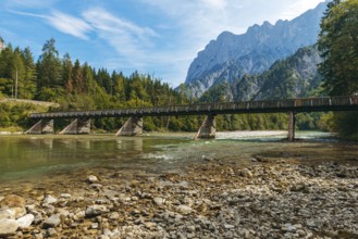 Wooden bridge over the Enns with stony bank and Reichenstein group in the background, Gesäuse,