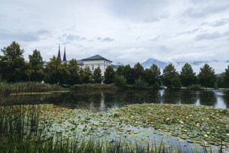 Admont Abbey behind a pond surrounded by trees, Admont, Styria, Austria