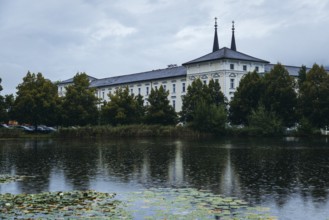 Admont Abbey is reflected in a pond surrounded by trees, Admont, Styria, Austria