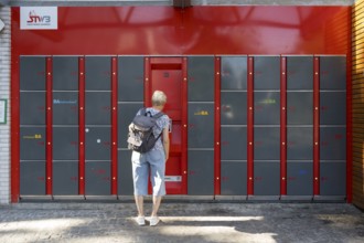 Woman standing in front of locker system, lockers, railway station, Bamberg, Upper Franconia,