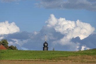 Tower of a chapel behind a meadow hill, cloudy sky, Köttweinsdorf, Upper Franconia, Bavaria,