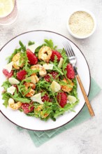 Fresh shrimp salad with arugula, grapefruit, and parmesan served in a bowl