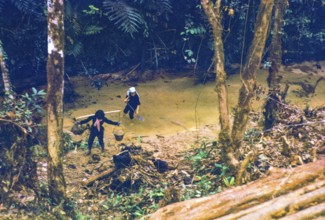 Captioned as 'Chinese women possibly panning for tin in jungle stream', near Fraser's Hill, Pahang,