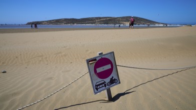 Prohibition sign stands in the sand of a wide beach under a blue sky, Prasonisi, beach, surf,