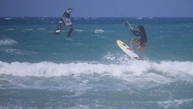 Kitesurfer dynamically jumping over a wave on the open sea, Prasonisi, beach, surf, windsurfer,
