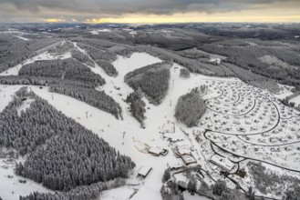 Aerial view of the snowy winter landscape of Winterberg with deserted ski lifts and slopes during