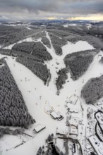 Aerial view of the snowy winter landscape of Winterberg with deserted ski lifts and slopes during