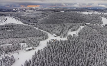 Aerial view of the snowy winter landscape of Winterberg with deserted ski lifts and slopes during