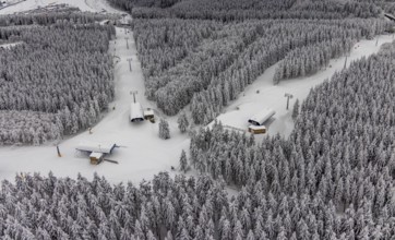 Aerial view of the snowy winter landscape of Winterberg with deserted ski lifts and slopes during