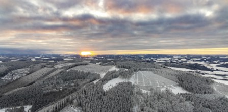 Aerial view of the sunset with a view over the snowy winter landscape from Winterberg to the