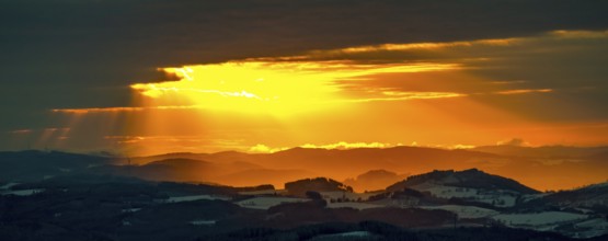 Aerial view of the sunset with a view over the snowy winter landscape from Winterberg to the