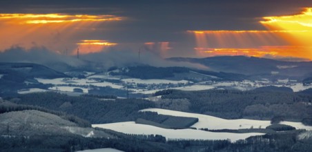Aerial view of the sunset with a view over the snowy winter landscape from Winterberg to the