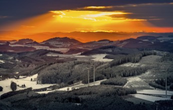 Aerial view of the sunset with a view over the snowy winter landscape from Winterberg to the