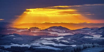 Aerial view of the sunset with a view over the snowy winter landscape from Winterberg to the