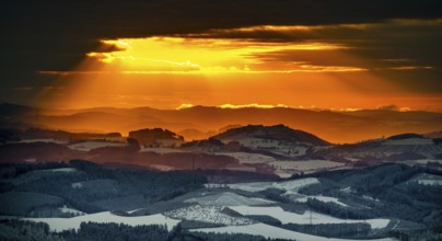 Aerial view of the sunset with a view over the snowy winter landscape from Winterberg to the