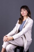 Elegant young businesswoman sitting and looking at the camera