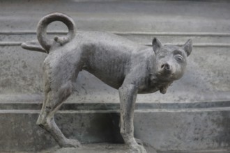 Detail with dog figure urinating at the Faun Fountain by Heinrich Apel 1986, holding one leg up,