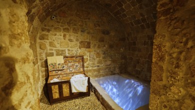A stone room with an illuminated immersion bath for ritual purification, Kahal Shalom Synagogue,