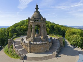 An imposing building surrounded by forests under a blue sky, aerial view, Kaiser Wilhelm Monument