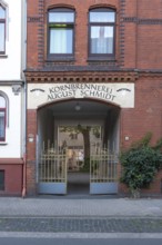 Photograph of the entrance to an old grain distillery with a wrought-iron golden Tor tor, Hainholz,