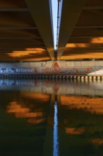 View across the Mittelland Canal to the underside and the graffiti-painted abutment of a bridge on