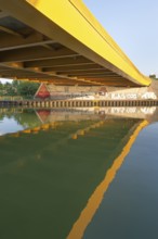 View across the Mittelland Canal to the underside and the graffiti-painted abutment of a bridge on