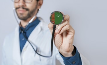 Doctor holding stethoscope with Turkmenistan flag. Turkmenistan health and care concept,