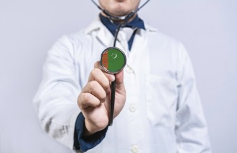 Doctor hands holding stethoscope with Turkmenistan flag. Turkmenistan health and care concept