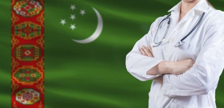 Doctor with crossed arms on Turkmenistan flag. Turkmen health and care concept. Female doctor on