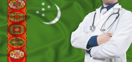 Turkmenistan healthcare concept. Male doctor on Turkmenistan flag. Doctor with crossed arms on