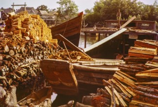 Loading wood timber products onto barge boat in timber yard, Johor Bahru, Johor, Malaya, Malaysia,