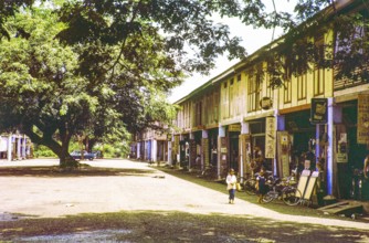 Row of Chinese shophouses businesses in building, unspecified location in Malaya, Malaysia, south