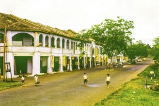 Row of Chinese shophouses businesses in building, unspecified location in Malaya, Malaysia, south