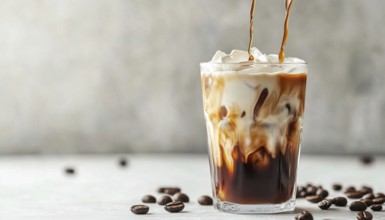 Refreshing Iced Coffee With Cream Being Poured On White Table. Cool And Invigorating Coffee Latte