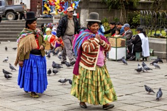 Two woman in colourful, traditional dress walk happily through a park, Traditionally dressed woman