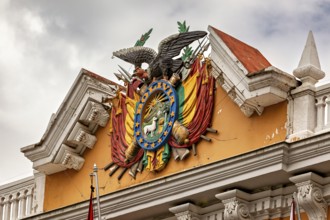 Detailed coat of arms with eagle on a historic building under a cloudy sky, The Presidential Palace