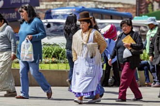 Woman in traditional dress with hat walking on a busy street, Traditionally dressed woman in the