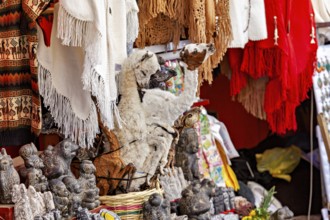 A market stall with a llama figure and colourful textiles represents Andean culture, The witches'
