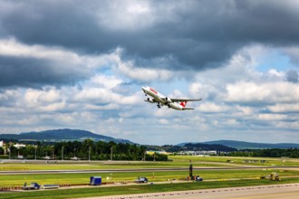 Swiss Airlines Passenger Airplane Take Off From the Runway and Flying Against Blue Sky and Clouds