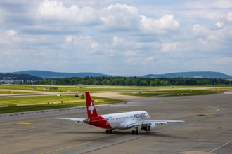 Helvetic Airways Passenger Airplane Taxiing on Runway in a Sunny Summer Day From the Airport in