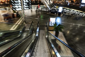 Inside Illuminated Zurich Airport with Escalator in Blurred Motion at Night in the Airport in
