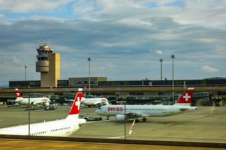 Swiss Airlines Passenger Airplane and Air Traffic Control Tower on the Airfield in a Sunny Summer