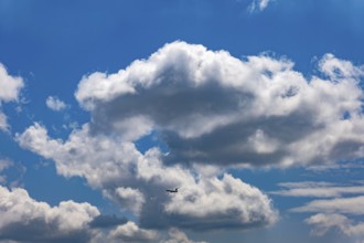 Passenger Airplane Flying Against Blue Sky and Clouds in a Sunny Summer Day From the Airport in