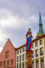 Old Town with House and Water Fountain with Statue and Tower with Sky and Clouds in a Sunny Autumn