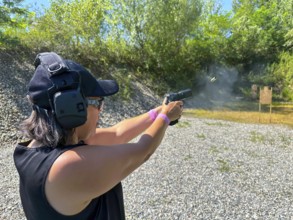 Woman Shooting in Motion on an Outdoor IPSC Shooting Range in a Sunny Summer Day in Switzerland